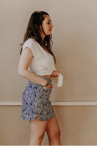 Femme de profil avec une jupe short imprimée.