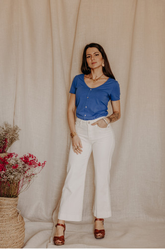 Femme avec un t-shirt manches courtes bleu et un denim blanc.