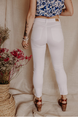 Femme de dos avec un pantalon blanc.