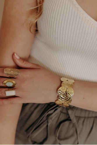 femme qui porte un bracelet jonc doré feuillage