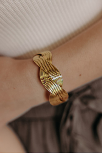 Pignet d'une femme qui porte un bracelet jonc doré