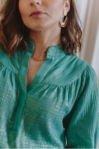 Détails d'une blouse en gaze de coton verte portée par une femme