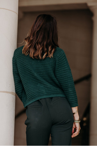 Gilet vert en tricot porté par une femme de dos