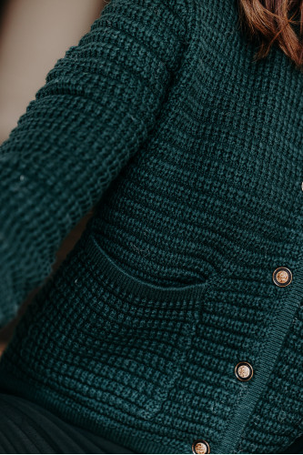 Détails d'un gilet vert en tricot porté par une femme