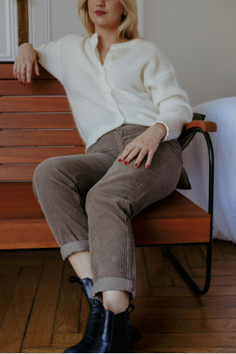 Femme assise avec un pantalon.