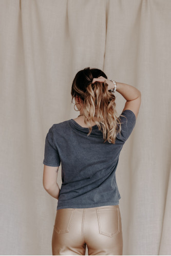 Femme de dos avec un t-shirt gris.