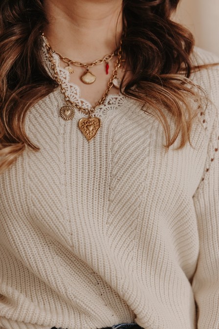 Femme portant un pull beige à dentelle. Femme portant un pull beige à dentelle.