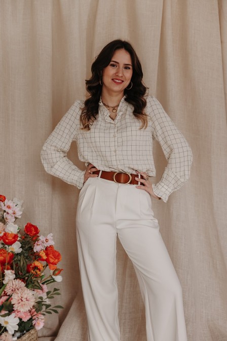 femme qui porte un pantalon chic écru et une blouse à carreaux