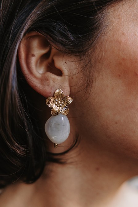 Femme avec des boucles d'oreilles fleurs. Femme avec des boucles d'oreilles fleurs.