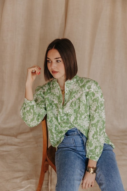 Femme avec une blouse verte imprimée.