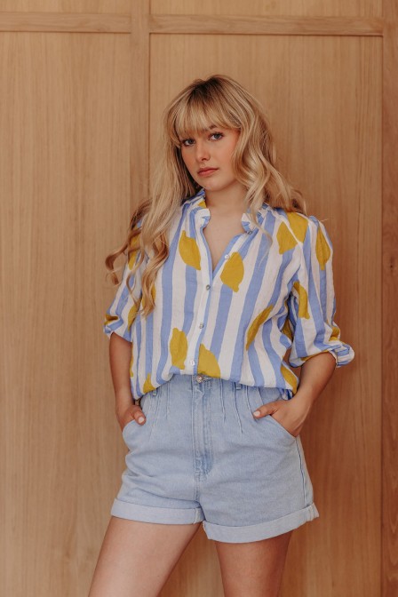 Femme avec une chemise rayée jaune.