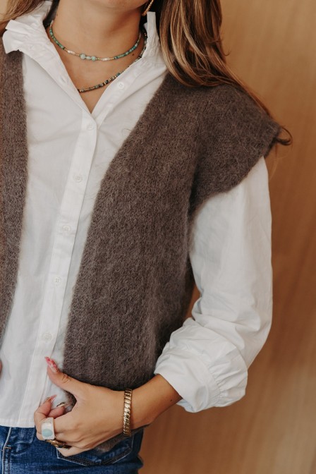 Femme assise avec un gilet sans manches. Femme assise avec un gilet sans manches.