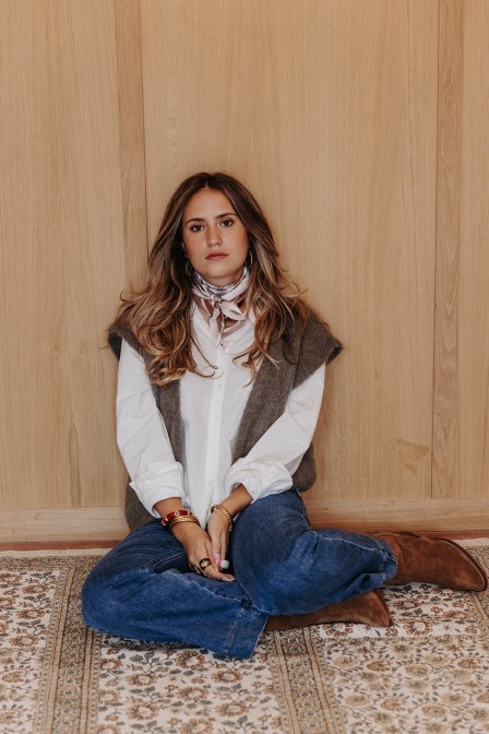 Femme assise avec un gilet sans manches. Femme assise avec un gilet sans manches.
