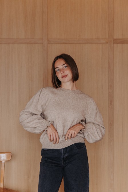 Femme avec un pull beige.